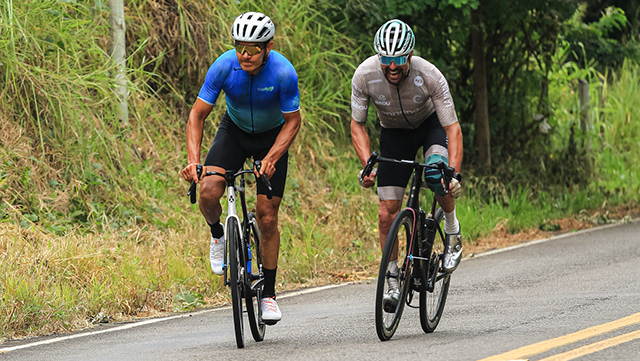 Dois ciclistas disputam uma prova em uma estrada